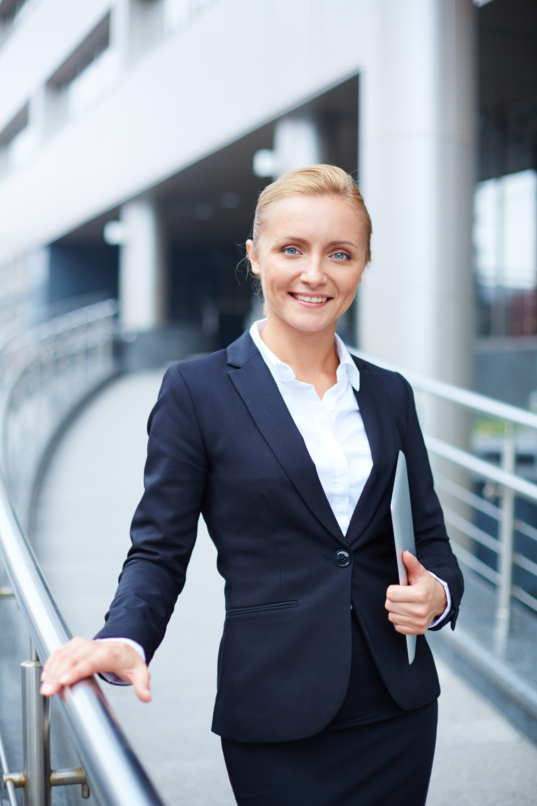 Young businesswoman with touchpad looking at camera