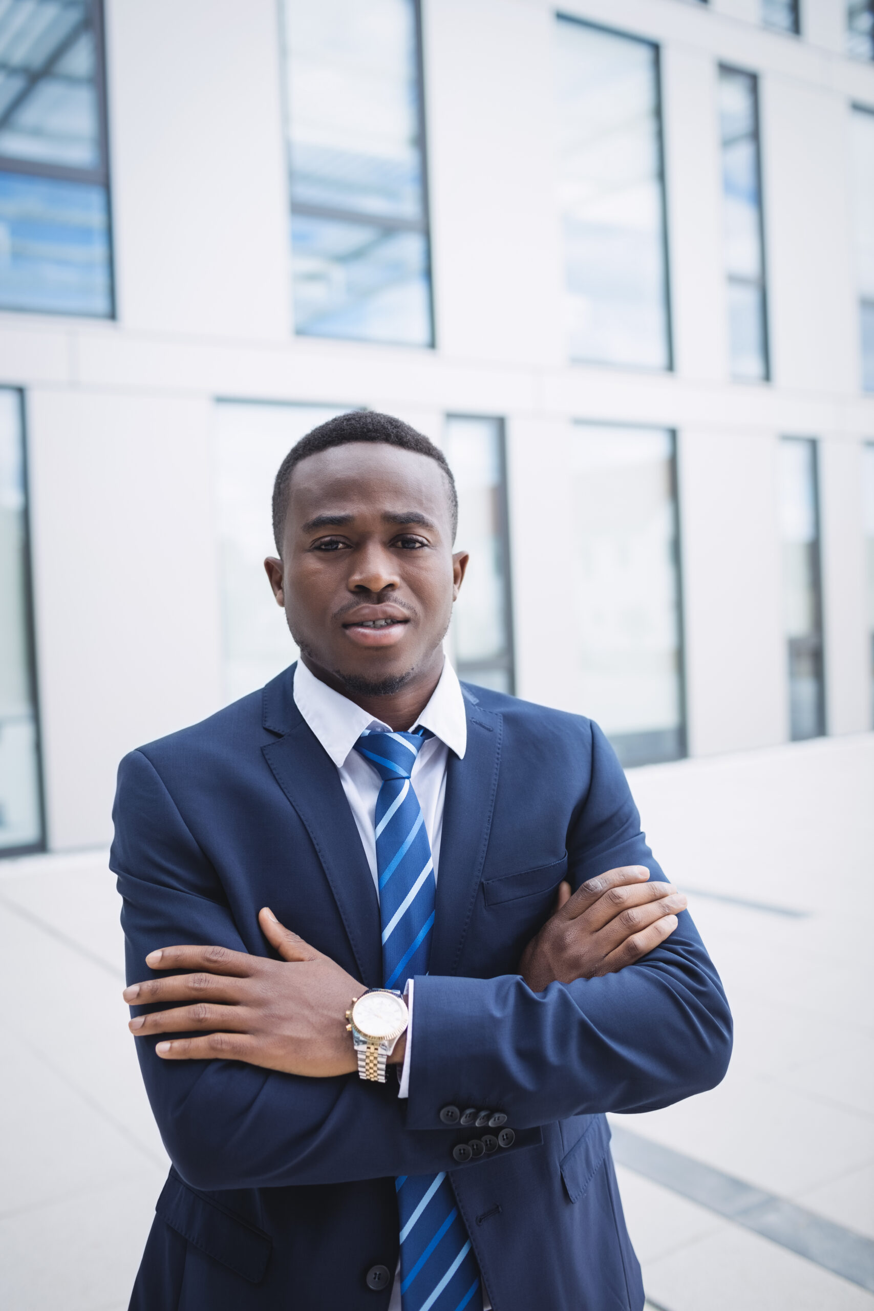 Portrait of a businessman with arms crossed standing outside office building